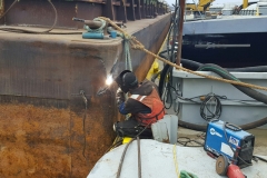 A C&B associate performing topside repair on a barge